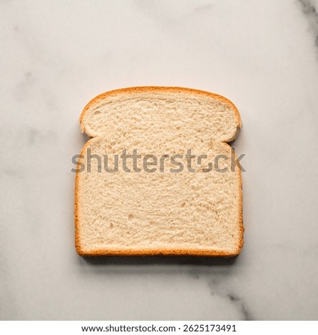 Close up of single slice of white bread isolated on marble counter.