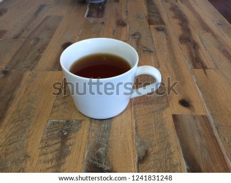 A close up of a single steaming cup of hot black chai tea isolated in a modern simple white ceramic mug on a beautiful unique rustic timber table in my house in Victoria, Australia.