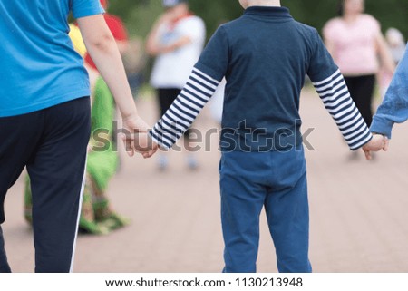 Close up of Sister hold hands with small children .