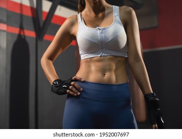 Close Up Of Six Pack. Strong Boxer Woman Posing Muscles, Punching Combat Punches In Boxing Sport Club Workout At Training Gym Fitness Center. Exercise Indoor Sport Equipment. People Lifestyle.