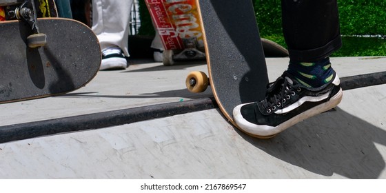 Close up of a skateboarding stunt or trick in the halfpipe or ramp. Unrecognizable person showing skating skills. Urban culture and lifestyle concept. More skateboards on the background.
