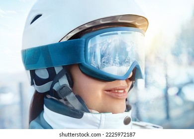 Cerca De Los Goggles De Esquí De Una Mujer Con El Reflejo De Las Montañas Nevadas. Retrato De Una Mujer En La Estación De Esquí En El Fondo De Las Montañas Y El Cielo.