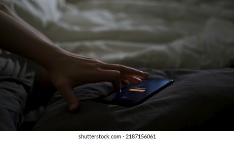 Close Up Of Sleeping Man Being Woken Up By His Phone Lying On The Bed. Concept. Male Hand Trying To Turn Off The Alarm Clock Lying Near On A Blanket At Home Early In The Morning.