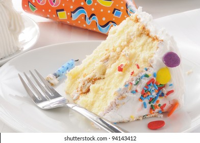 Close up of a slice of birthday cake with a party hat