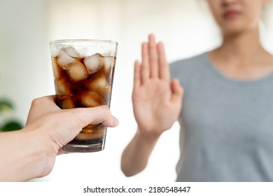 Close up slim woman hand push out say no avoid and reject her favorite cola soft drink high sweet sugar for good health diet and calories control - Shutterstock ID 2180548447
