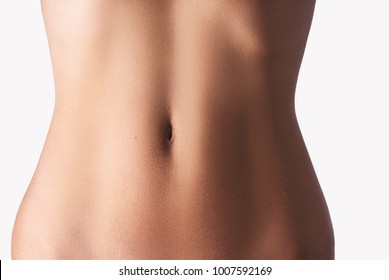 Close up of slim young woman belly isolated on white.