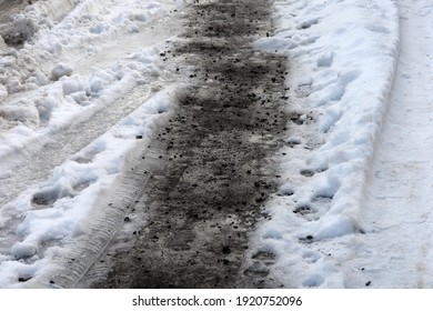 Close Up Of A Slippery, Icy Pedestrian Walkway Sprinkled, Covered In Ash, Coal, Charcoal. Ice On Pavement. Morning Frost During Thaw. Thaw In Winter. Poland, Europe