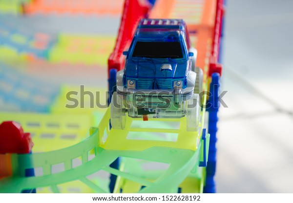 close up\
of a small blue toy car on the train\
tracks