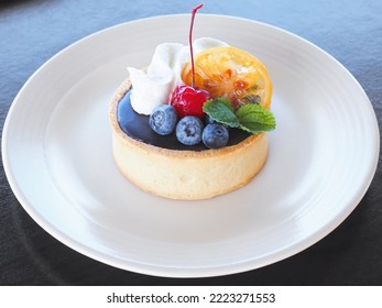 Close up small cake with fruit and whipping cream on white plate. Bakery cupcake. - Powered by Shutterstock