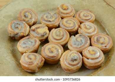 Close Up Of Small Cinnamon Rolls With Icing On Ceramic Bunch Or Breakfast Party Platter