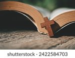 close up small cross and book on wood table, copy space for text