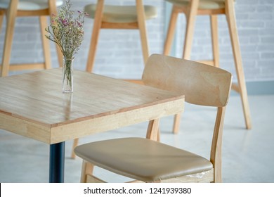 Close Up Of Small Dining Table With Scandinavian Style  Chairs And Decorative Flower In A Bright, Open Space Living Room Interior. Cafe And Home Decoration In Minimalist Stlye.
