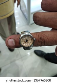 A Close Up Of A Small Finger Watch. It Can Be Wear As A Ring In Your Fingers And Has A Small Analogue Watch Too. It Looks Very Stylish And Different.