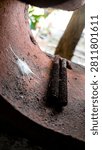 Close up of a small spider web and rusted threaded bolts inside a weathered metal pipe