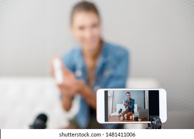 close up of smart phone screen with video broardcasting of makeup artist youtuber influencer broadcasting demonstrating cosmetic products live online