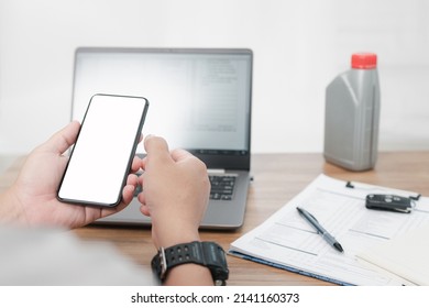 Close up smartphone with white display and hand a man holding check the schedule for car maintenance appointments and inform the customer to bring the car to use for service Drain the engine oil - Powered by Shutterstock