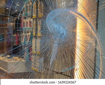 Close Up Of Smashed Shop Window, Broken Glass. Burglary Attempt. Protective Or Tempered Glass Or Film, Screen Protector. Bulletproof, Resistant Glass. Smartphone Shop Or Store. Part Of A Serie.