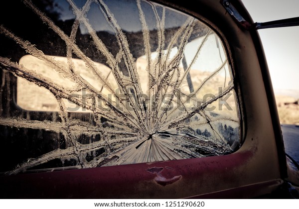 Close up of a smashed window on an\
abandoned car in a ghost town outside of Jerome,\
Arizona.