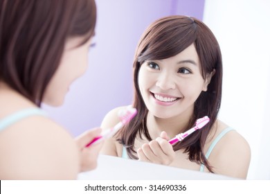 Close Up Of Smile Woman Brush Teeth And Look Mirror. Great For Health Dental Care Concept. Asian Beauty