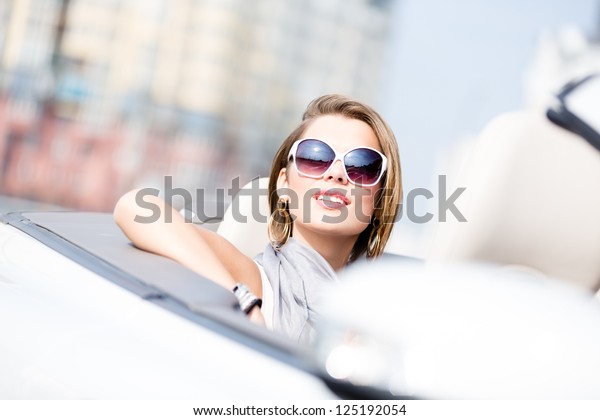 Close up of smiley woman in the cabriolet
wearing cute sunglasses
