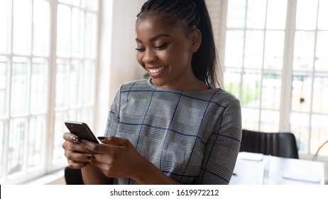 Close Up Of Smiling African American Businesswoman Hold Cellphone Browsing Wireless Unlimited Fast Internet, Happy Biracial Woman Employee Using Smartphone, Check Mail On New Cellular Device