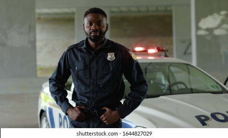 Close Up Smiling African American Young Man Cops Stand Near Patrol Car Look At Camera Enforcement Happy Officer Police Uniform Auto Safety Security Communication Control Policeman Portrait Slow Motion