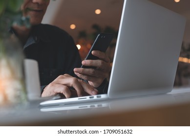 Close up of smiling asian casual business man using zoom meeting online app, facetime video calling via mobile phone application, remotely working on laptop computer in coffee shop, social distancing - Powered by Shutterstock