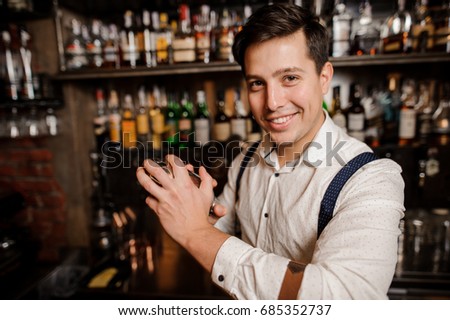 close up smiling bartender making a cocktail