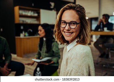 Close Up Of Smiling Caucasian Business Woman Sitting Contently In Office Lounge Chatting With Clients Before Important Business Meeting 