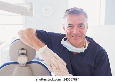 Close Up Of Smiling Dentist Leaning Against Dentists Chair In Dental Clinic