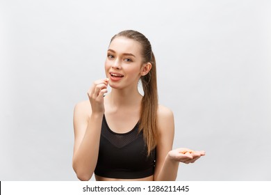 Close Up Of Smiling Fitness Woman Taking Pill With Cod Liver Oil Omega-3 , Vitamin D, E, A Fish Oil Capsules