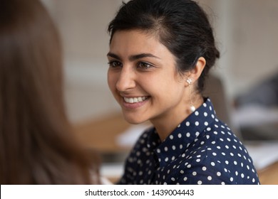 Close up of smiling indian female look at friend talk chatting discussing ideas, happy positive young ethnic girl speak with girlfriend listening or sharing thoughts. Communication, feedback concept - Powered by Shutterstock