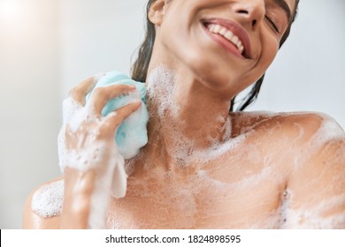 Close Up Of Smiling Lady With Foam On Her Skin Washing Body With Exfoliating Sponge