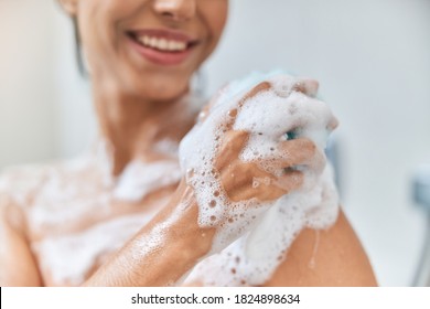 Close Up Of Smiling Lady With Foamy Washcloth In Her Hand Taking Shower At Home