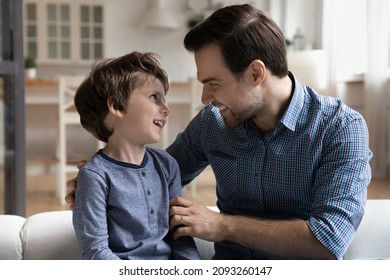 Close Up Smiling Loving Dad Talking With Little Son, Sitting On Cozy Sofa At Home, Happy Young Caucasian Father And Adorable Toddler Child Boy Having Fun, Enjoying Pleasant Conversation Together