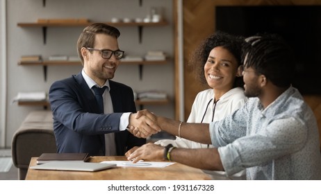 Close Up Smiling Manager And African American Family Shaking Hands, Making Successful Investment Or Insurance Deal, Overjoyed Young Couple And Realtor Broker Handshaking, Taking Loan Or Mortgage