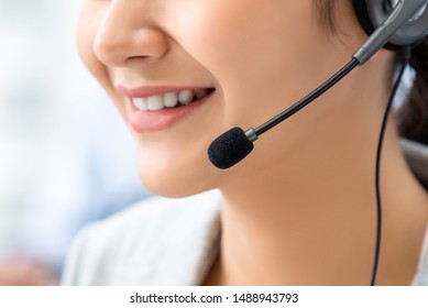 Close Up Of Smiling Woman Customer Service Operator Wearing Microphone Headset In Call Center