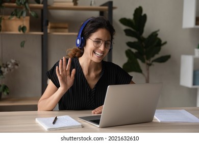 Close Up Smiling Woman In Headphones And Glasses Waving Hand At Webcam, Using Laptop, Chatting Online, Making Video Call, Teacher Greeting Student, Internet Lesson, Involved In Internet Meeting