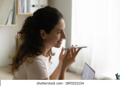 Close Up Smiling Woman Holding Smartphone Near Mouth, Recording Voice Message, Chatting, Sitting At Work Desk, Businesswoman Making Call, Talking By Speakerphone, Activating Assistant On Phone