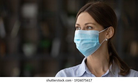 Close Up Of Smiling Young Caucasian Woman In Facial Mask Look In Distance Think Dream Of Coronavirus Pandemics End. Happy Female In Facemask Against Corona Virus Epidemics. Covid-19 Concept.