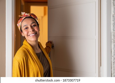 Close Up Of Smilingblack Woman With Head Band Leaving Home During The Day. In Front Of Apartment Door. Individuality, Style, Identity Concept.