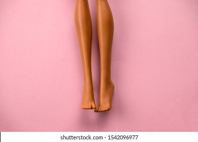 Close Up Of Smooth Legs Of A Plastic Toy Doll On A Soft Pink Background