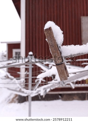 Close up of a snow covered clothes pin on a clothes line in january.