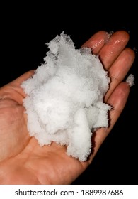 Close Up Of Snowball Melting Into Water On Womans Palm With Dark Background