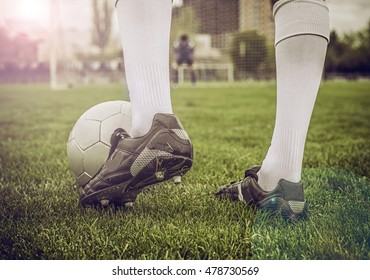 Close up of a soccer ball and a feet of a soccer player 
