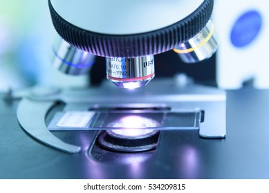 Close up and soft focus of objective lens microscope in laboratory.Blue tone.