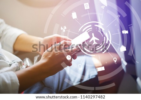 close up soft focus on businessman hand holding smartphone for checking work or playing in the aircraft with virtual interface of air transportation symbol technology,business travel concept