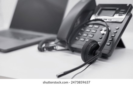 close up soft focus on telephone devices with copy space background at office desk in operation room for customer service support (call center) concept