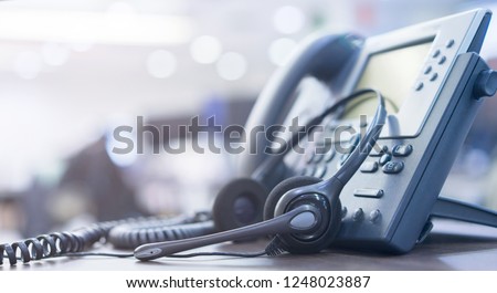 close up soft focus on telephone devices with copy space background at office desk in operation room for customer service support (call center) concept