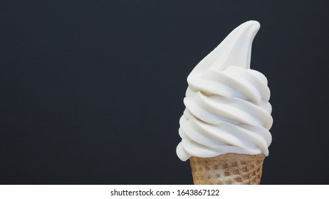 Close Up Of Soft Serve Ice Cream Cone On Black Background.